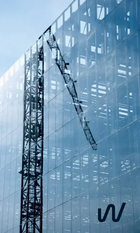 Crane on a glass building under construction
